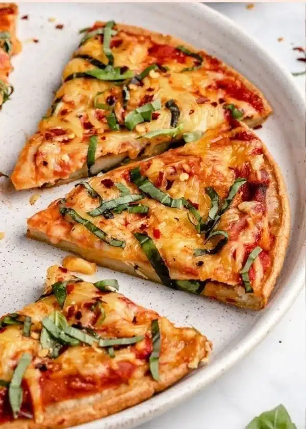 Homemade quinoa pizza crust fresh out of the oven with toppings.